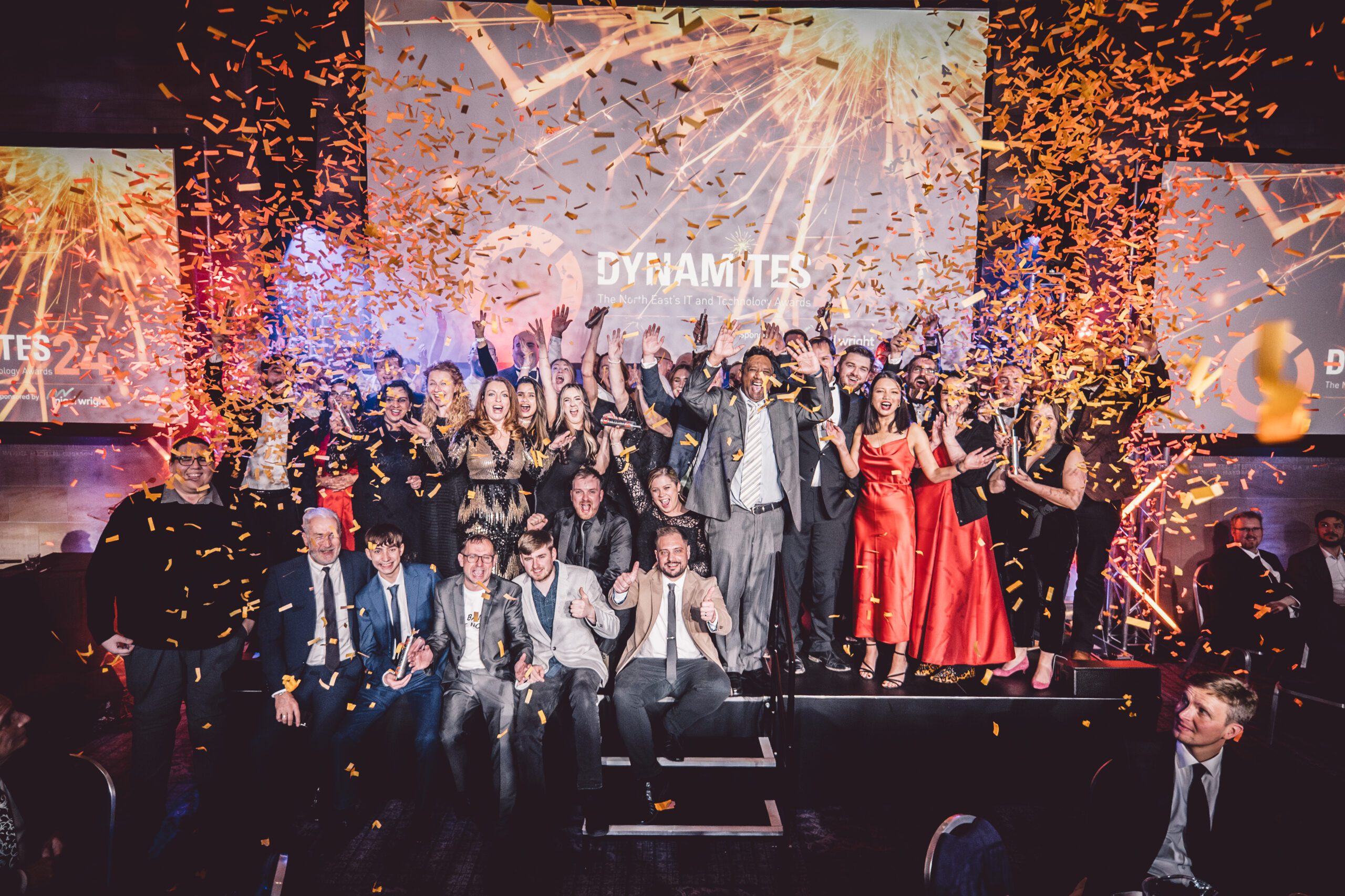 Celebration on stage at the Dynamites Awards 2024, with award recipients and gold confetti